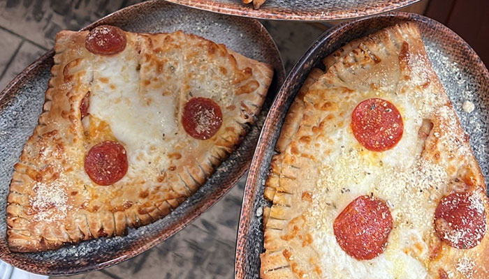 Two slices of pepperoni pizza with stuffed crust from the Reel Java Lunch Menu on oval plates.